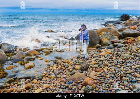 Tourist photographs incoming Atlantic Ocean waves in Gros Morne National Park, Newfoundland. Canada. MR Stock Photo