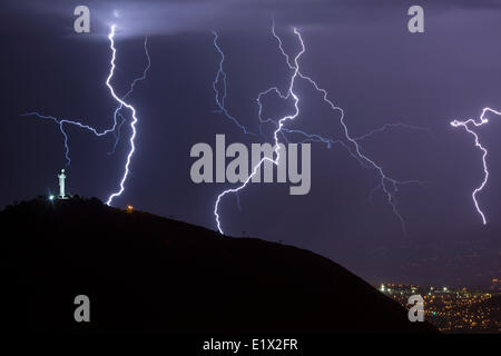 Lightning during a thunderstorm over the city of Cochabamba, Bolivia. El Cristo is in the foreground. Stock Photo