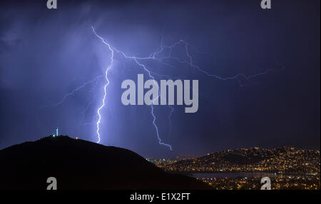 Lightning during a thunderstorm over the city of Cochabamba, Bolivia. El Cristo is in the foreground. Stock Photo