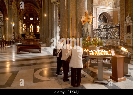 Women lighting candles in the Roman catholic church of Santa Maria Sopra Minerva, Rome, Italy Europe Stock Photo