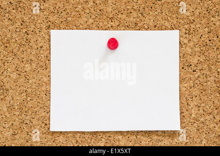 blank white paper notice posted on cork board with red push pin Stock Photo