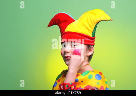 Boy dressed buffoon (Harlequin / Clown/Buffoon) on a bright background Stock Photo