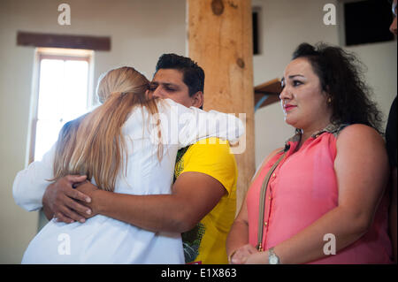 Tucson, Arizona, USA. 10th June, 2014. DANIEL NEYOY RUIZ, a Mexican national living, working and paying taxes in the U.S. since 2005, was granted a stay on his deportation order by Immigration and Customs Enforcement, allowing him to leave the Tucson, Ariz. church where he and his family have taken sanctuary for nearly a month. Ruiz is pictured hugging a pastor at the church where he and his family stayed. Ruiz's stay is valid for a year, and his attorney remains hopeful that he'll be eligible for renewal - or that the government will create a path to regular immigration Stock Photo