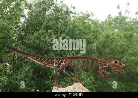 Large Sculpture of a running bipedal dinosaur created out of recycled scrap metal by Mowlam Metalcraft of Dorchester. Dorset, England, United Kingdom. Stock Photo