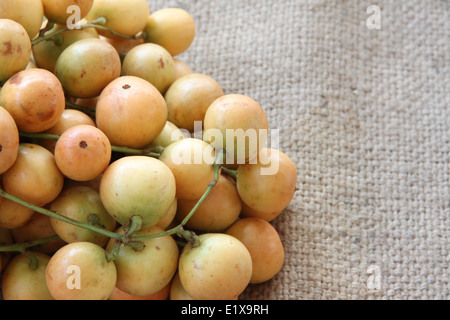 Baccaurea ramiflora or burmese grapes on sackcloth of background. Stock Photo