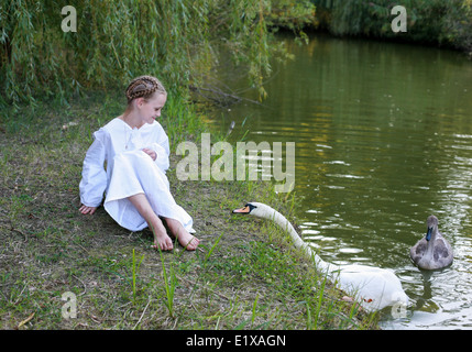 A girl sits on the shore of a pond in an autumn park Stock Photo - Alamy