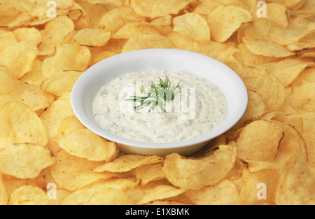 Chip Dip - A bowl of dip surrounded by potato chips. Stock Photo