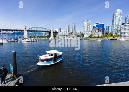 False Creek Ferry leaving Granville Island, Burrard Bridge in background. Vancouver, British Columbia, Canada. Stock Photo