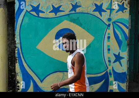 Salvador. 11th June, 2014. A man walks by a mural with a flag of Brasil in Salvador Bahia, June 10 2014. the World Cup 2014 will be held in Brazil from 12 June to 13 July. © Jhon Paz/Xinhua/Alamy Live News Stock Photo