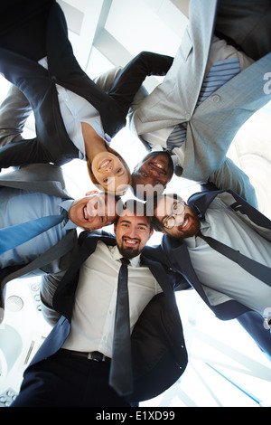 Group of friendly businesspeople in suits standing head to head Stock Photo