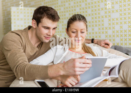 Happy young couple using tablet PC at home Stock Photo