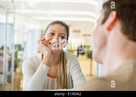 Smiling young woman looking at man in restaurant Stock Photo