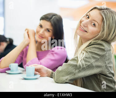 Portrait of young businesswomen smiling at cafeteria table