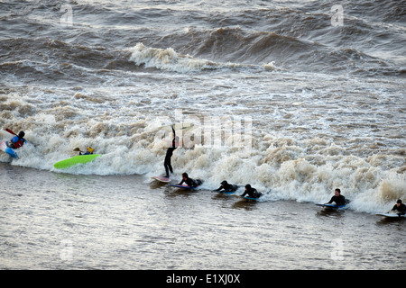 Surfers and canoeists riding the Severn Bore at Newnham-on-Severn, Gloucestershire UK 2014 Stock Photo