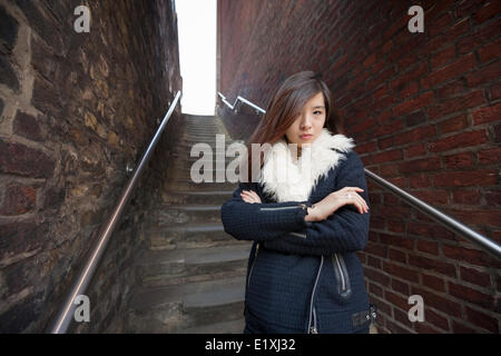 Portrait of confident woman with arms crossed standing against steps at London, England, UK Stock Photo