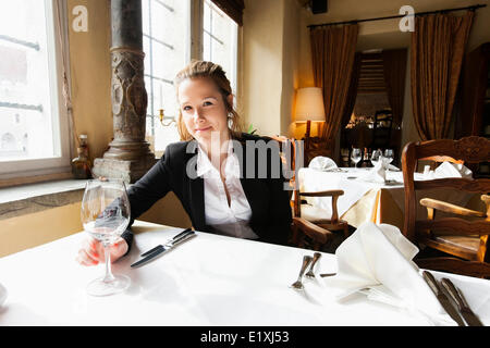 Portrait of beautiful customer with wine glass at restaurant table Stock Photo