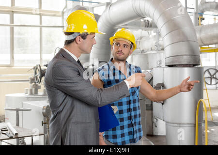 Worker with manager inspecting industrial area Stock Photo