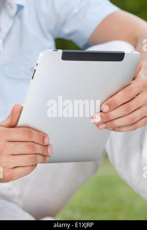 Midsection of man using digital tablet in park Stock Photo