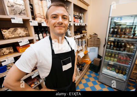 Portrait of confident mid adult salesman standing hands on hips in grocery store Stock Photo