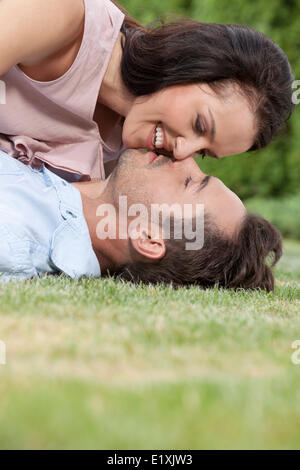 Side view of loving young couple about to kiss in park Stock Photo
