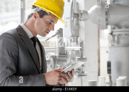 Young male supervisor using tablet PC in industry Stock Photo