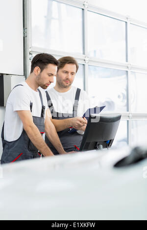 Male repair workers working in automobile repair shop Stock Photo