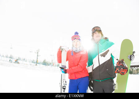 Young couple with snowboard and skis in snow Stock Photo