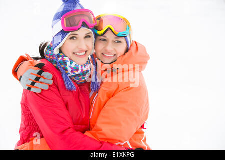 Portrait of happy young women in warm clothing embracing outdoors Stock Photo