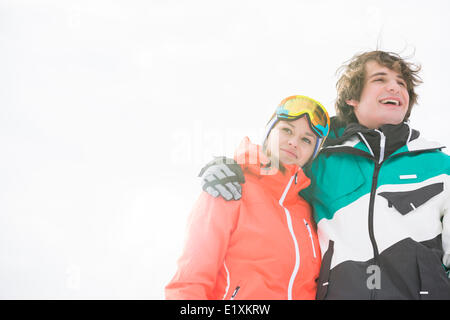 Loving young couple in warm clothing against clear sky Stock Photo