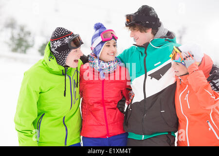 Portrait of young friends standing together in snow Stock Photo