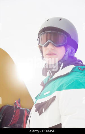 Handsome young man holding snowboard outdoors Stock Photo