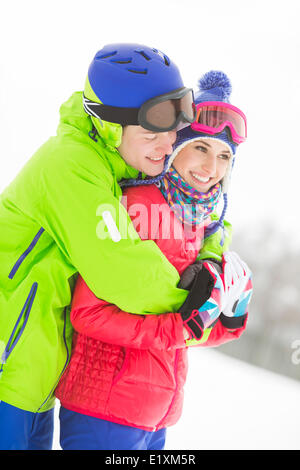 Happy loving man hugging woman in snow Stock Photo