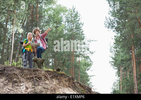 Hiking couple with map discussing over direction in forest Stock Photo