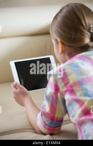 Rear view of girl using tablet PC at home Stock Photo