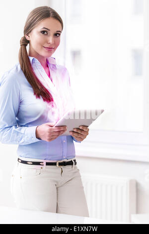 Portrait of young businesswoman using digital tablet in office Stock Photo