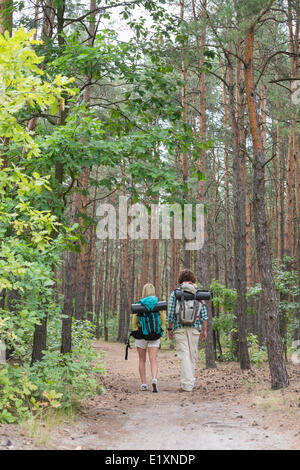 Rear view of hiking couple walking in forest Stock Photo
