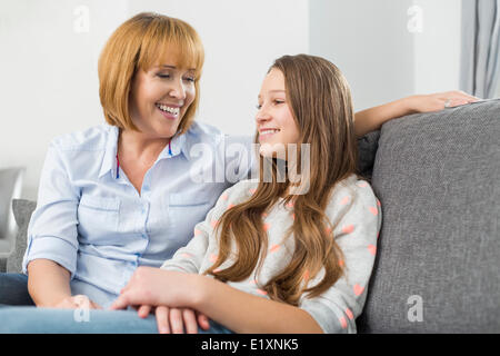 Happy mother and daughter relaxing on sofa at home Stock Photo