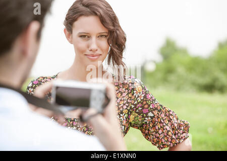 Portrait of confident woman being photographed by man in park Stock Photo