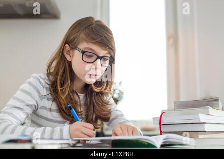 Teenage girl doing homework at table Stock Photo