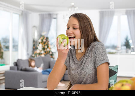 Happy girl eating apple at home Stock Photo