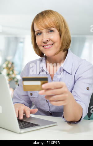 Portrait of happy woman shopping online at home during Christmas Stock Photo