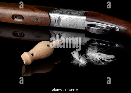 wooden whistles for calling ducks with a feather and a hunting gun. Stock Photo