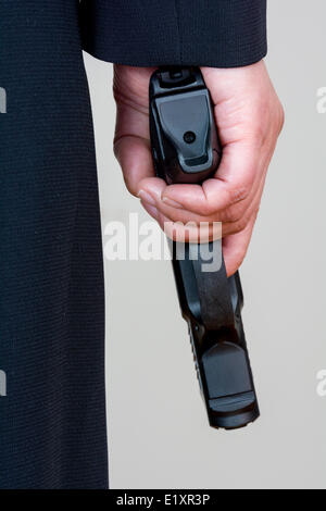 Woman holding hand gun on white background Stock Photo