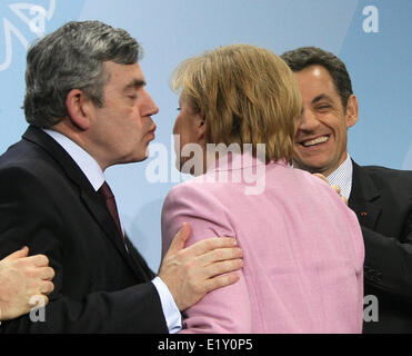 British prime minister Gordon Brown (l) kisses German chancellor Angela Merkel's cheek (M), next to her French president Nicolas Sarkozy, on the 22nd of February in 2009 on the occasion of the G20 preparation summit in Berlin. Stock Photo