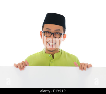 malay male with blank card during hari raya Eid al-Fitr aidilfitri celebration Stock Photo