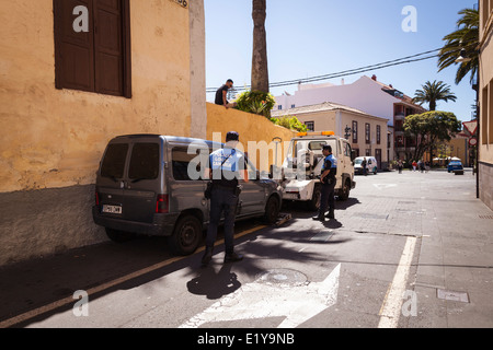Police and tow truck taking away an illegally parked vehicle in the old town of San Cristobal de La Laguna, Tenerife, Stock Photo