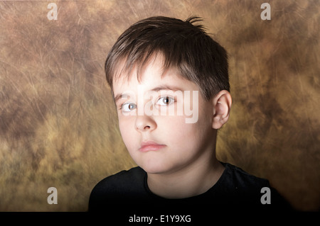 Portrait of a serious boy of seven, who looks frightened, scared. Studio shot Stock Photo