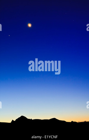 Moon on the Dark Blue Sky among mountains. Antarctica. Stock Photo