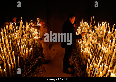 Catholic pilgrims at the village of El Rocio light candles in the Chapel of Remembrance during the Romeria festival in Spain Stock Photo