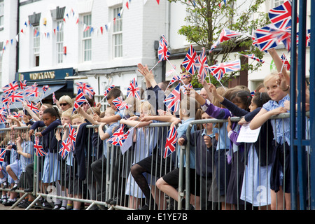 Crowds of schoolchildren line the streets of warwick for a freedom parade by the warwickshire fusilliers waving union jack flags Stock Photo